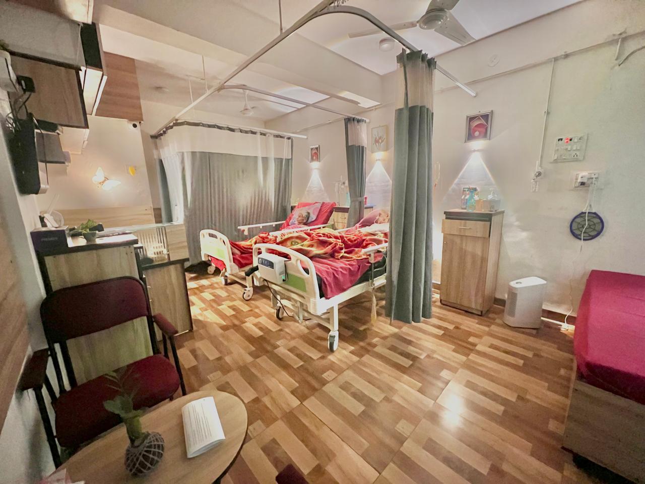 Spacious, warmly-lit care ward with curtained beds